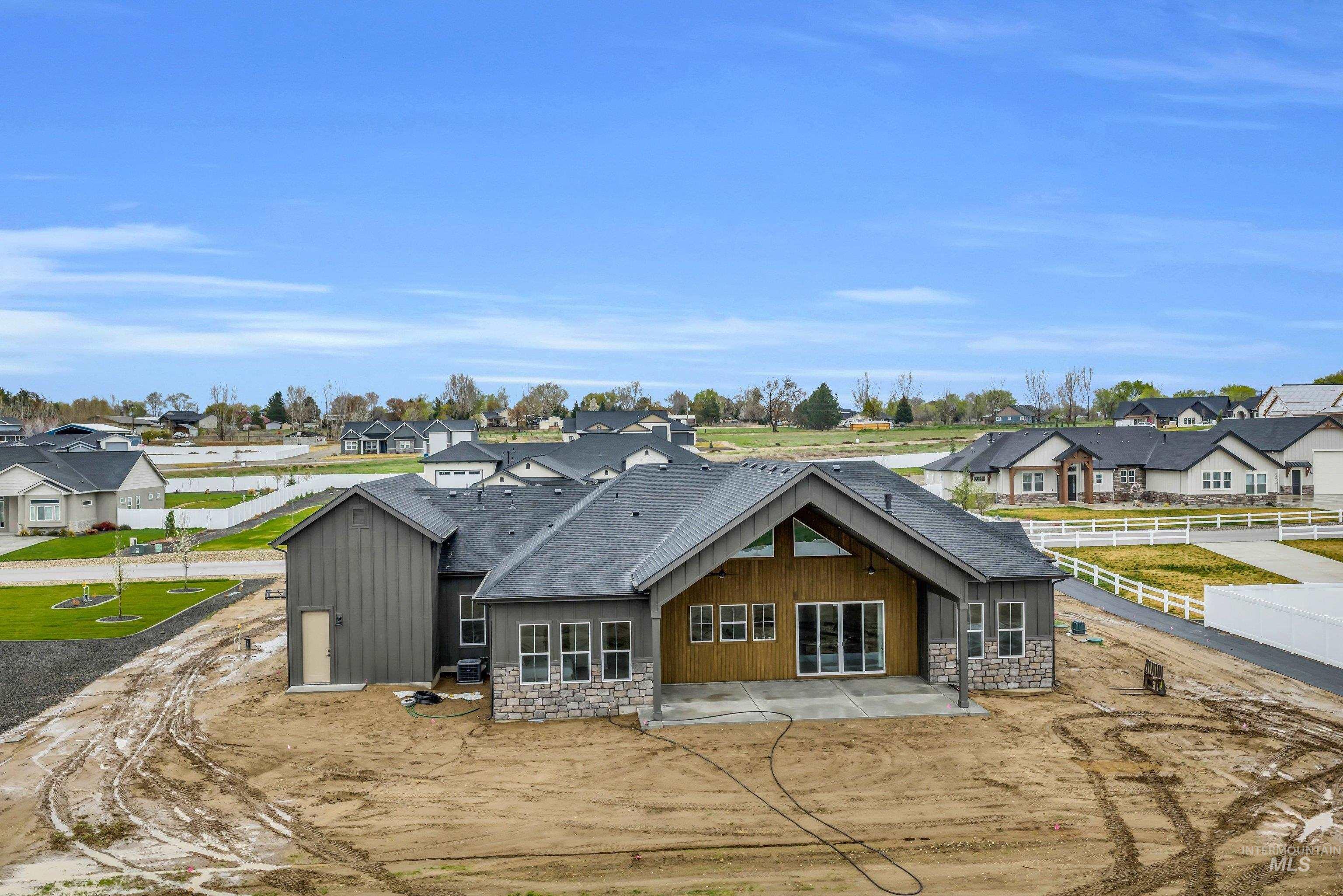 24871 Ardmore Court Caldwell, ID 83607 - Photo 32 of 44 Rear view of property with stone siding, a patio area, a residential view, and a shingled roof