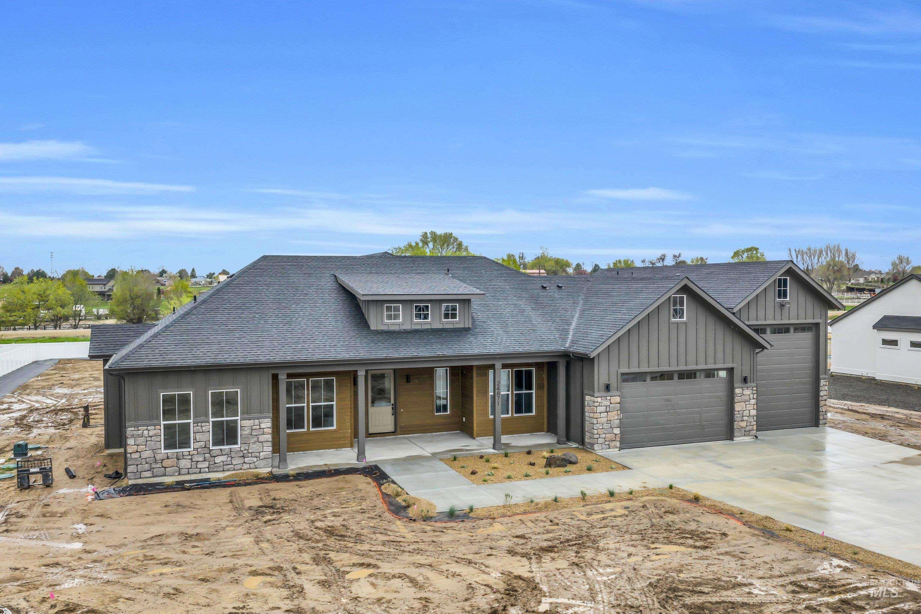 24871 Ardmore Court Caldwell, ID 83607 - Photo 34 of 44 Craftsman-style house featuring stone siding, roof with shingles, a porch, board and batten siding, and driveway