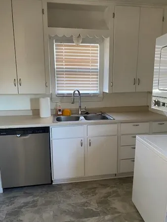 a kitchen with a sink cabinets and window