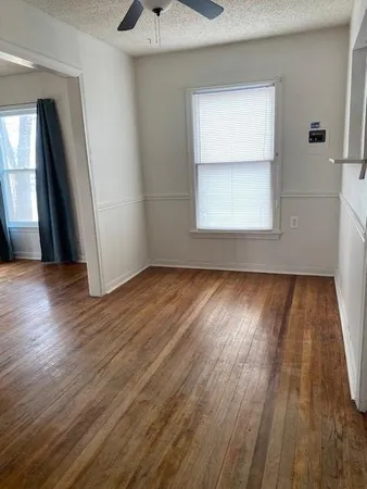 an empty room with wooden floor and a window