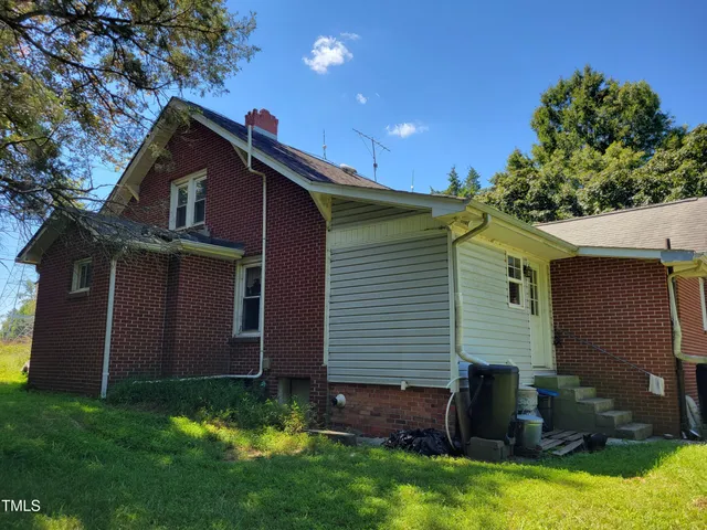 a view of house with yard and outdoor seating