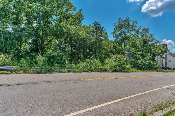 a view of a house with a yard and a street