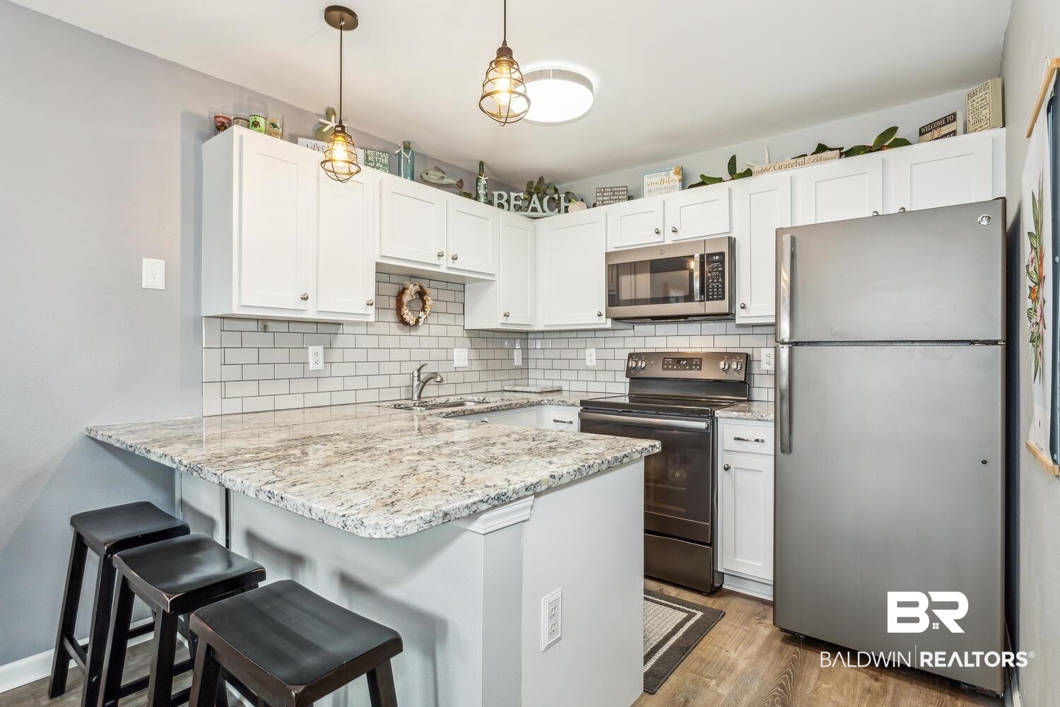 13551 Johnson Beach Road, Unit 112E Pensacola, FL 32507 - Photo 12 of 42 Kitchen featuring kitchen peninsula, white cabinets, and stainless steel appliances