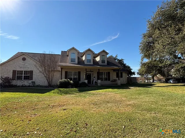 a view of a house with a big yard and large trees
