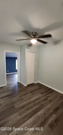 a view of an empty room with wooden floor