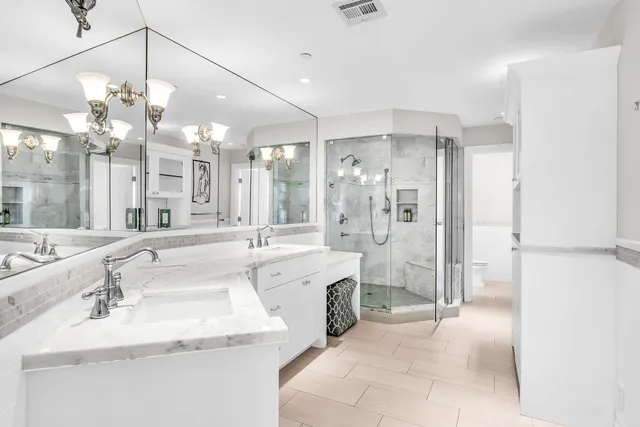 a bathroom with a granite countertop sink mirror and shower