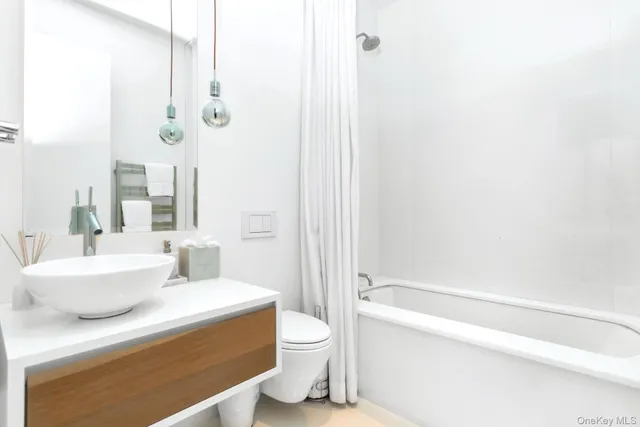 a bathroom with a granite countertop sink a toilet and shower