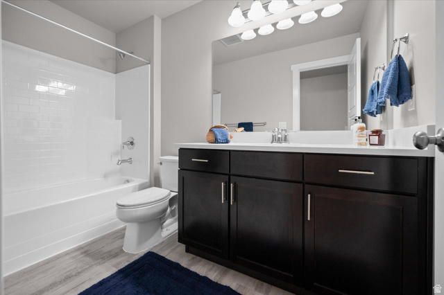 3359 Eurasian Crane Road Clinton, UT 84015 - Photo 34 of 71 Bathroom featuring vanity, shower / bath combination, and light wood-type flooring