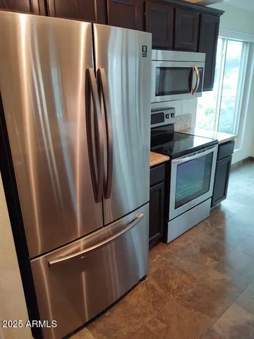 a metallic refrigerator freezer sitting in a kitchen