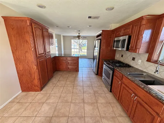 a kitchen with stainless steel appliances granite countertop a refrigerator and a sink