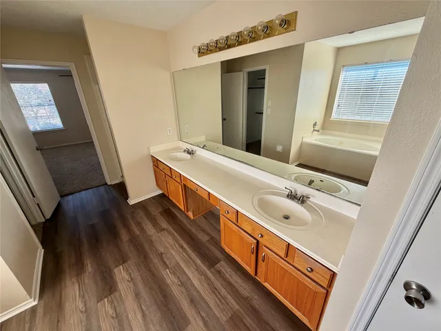 a bathroom with a bathtub a sink and a window