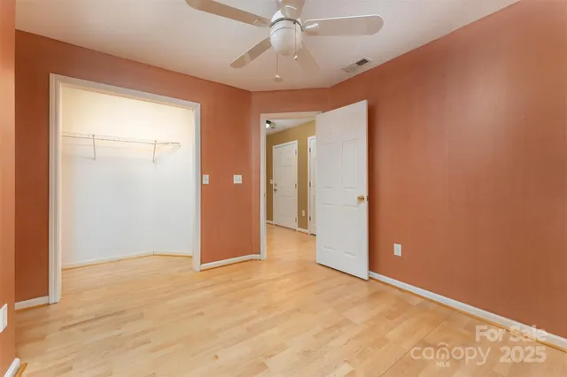 a view of empty room with wooden floor and windows