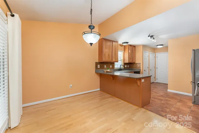 a view of kitchen with granite countertop cabinets and refrigerator
