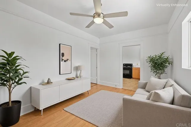 an empty room with wooden floor closet and windows