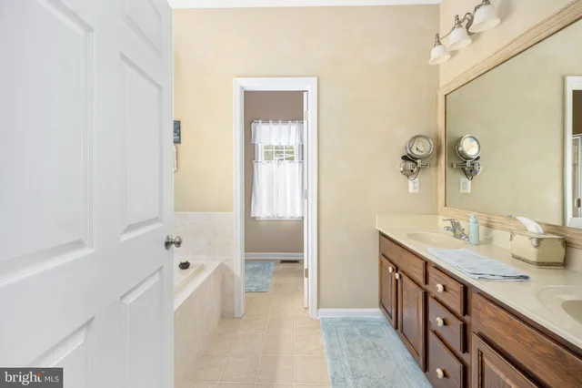 a view of a white house with a yard and large tree