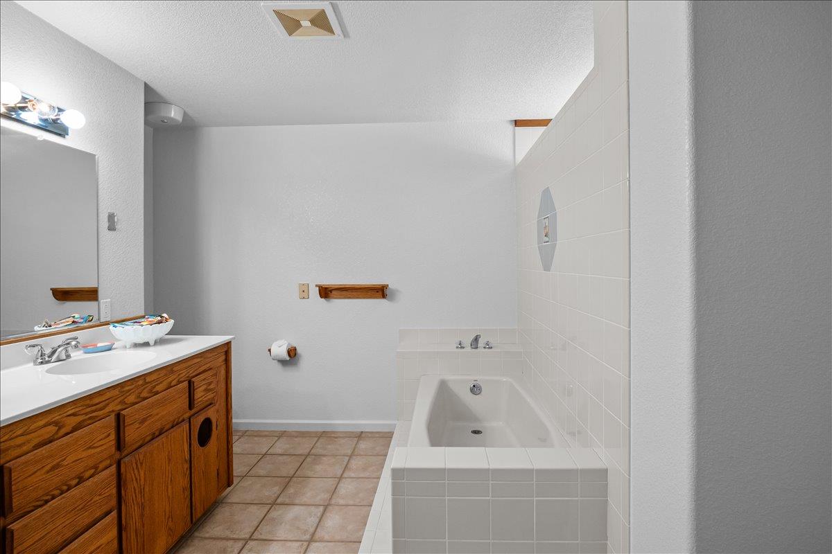 893 Wetherbee Avenue Manteca, CA 95337 - Photo 16 of 39 a bathroom with a tub sink toilet and mirror