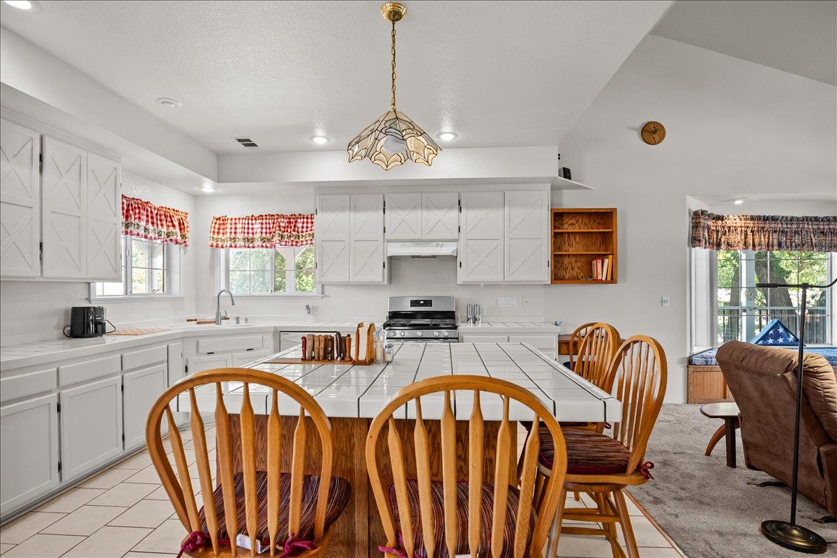 893 Wetherbee Avenue Manteca, CA 95337 - Photo 6 of 39 a very nice looking kitchen with granite countertop a stove a sink dishwasher a dining table and chair with wooden floor