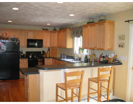 600 Boston Road Groton, MA 01450 - Photo 5 of 13 a kitchen with granite countertop a refrigerator and a stove top oven