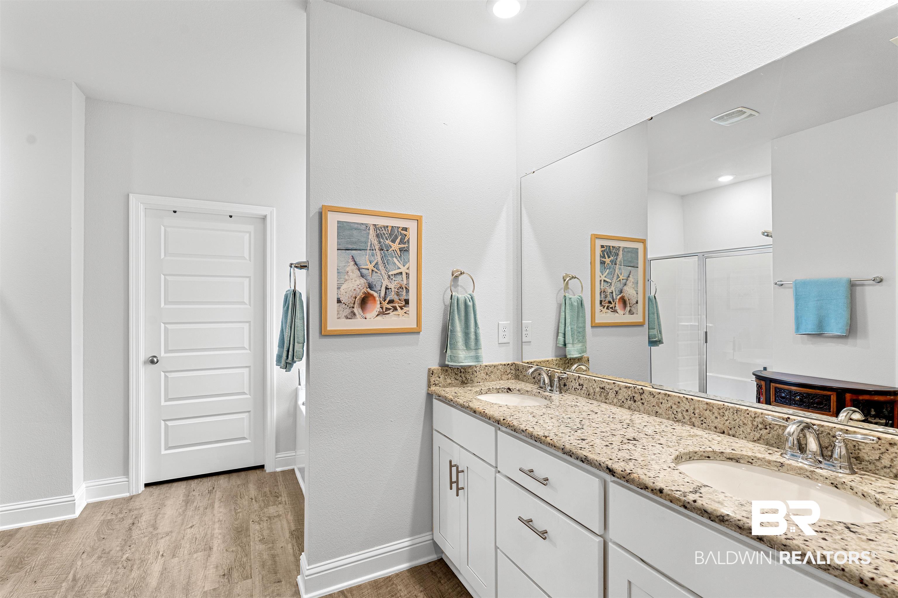 697 Calibre Street Fairhope, AL 36532 - Photo 10 of 18 Bathroom featuring double vanity, a shower stall, and light wood-type flooring