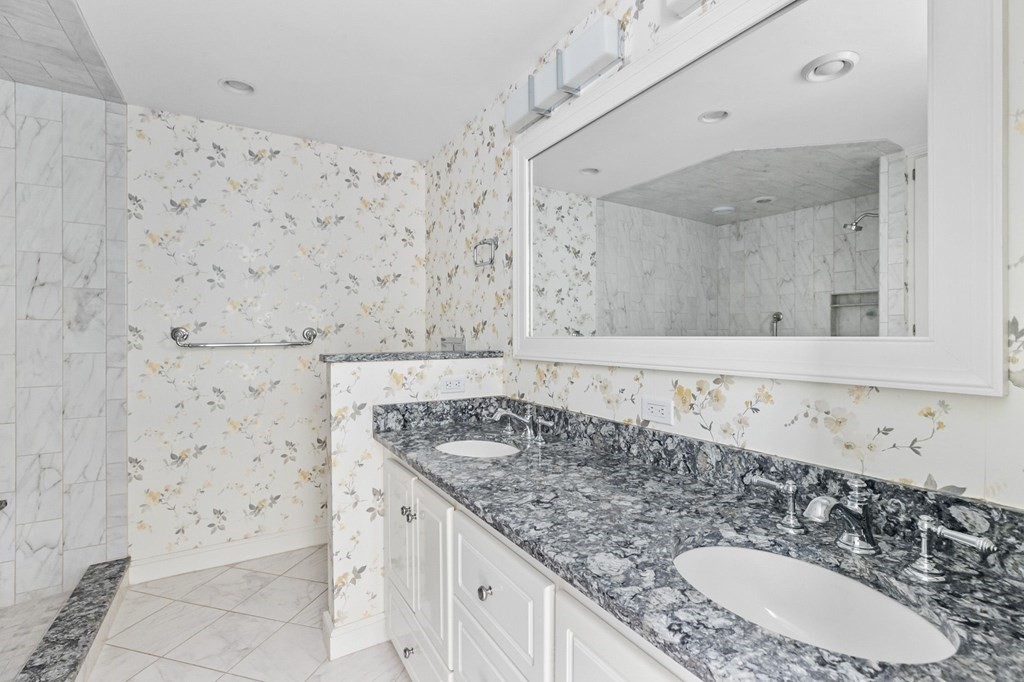 50 Floret Circle, Unit 50 Hingham, MA 02043 - Photo 13 of 28 a bathroom with a granite countertop sink a mirror and shower