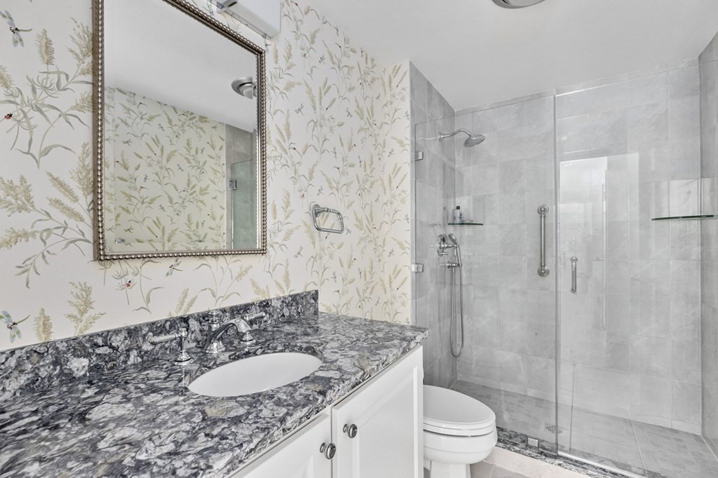50 Floret Circle, Unit 50 Hingham, MA 02043 - Photo 15 of 28 a bathroom with a granite countertop sink toilet a mirror and shower