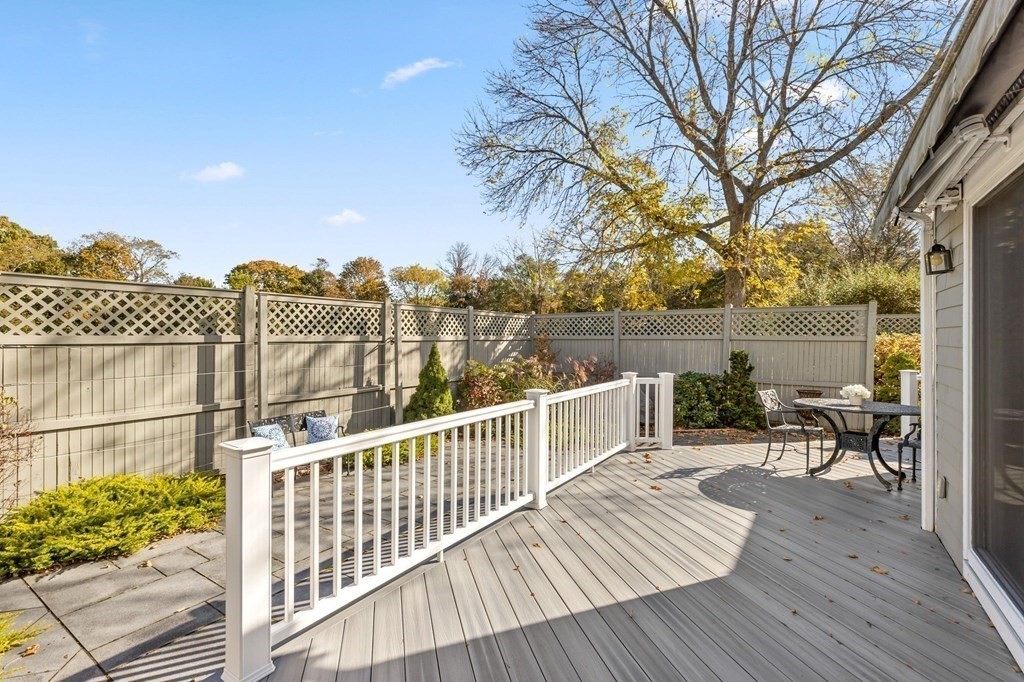 50 Floret Circle, Unit 50 Hingham, MA 02043 - Photo 22 of 28 a view of a roof deck with table and chairs a barbeque with wooden floor and fence