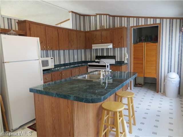 343 Will Boone Road Mocksville, NC 27028 - Photo 4 of 16 Kitchen. A large island provides loads of counter space. The dishwasher is not pictured but convenient to the sink on the back side of the island. Frig stays!