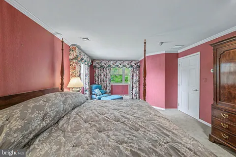 a bedroom with a bed dresser and a window