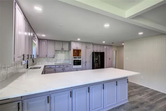 a large kitchen with stainless steel appliances a large counter top