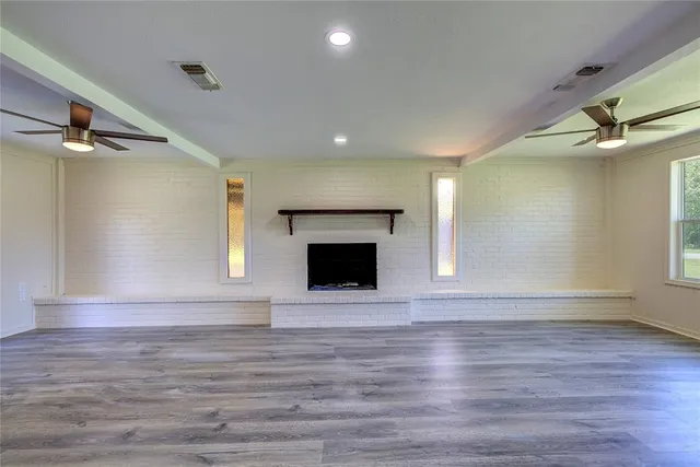 a view of an empty room with a fireplace and a window