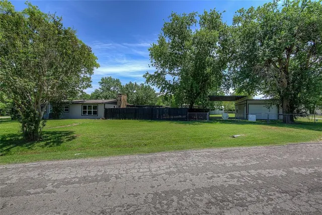 a front view of a house with a yard and trees