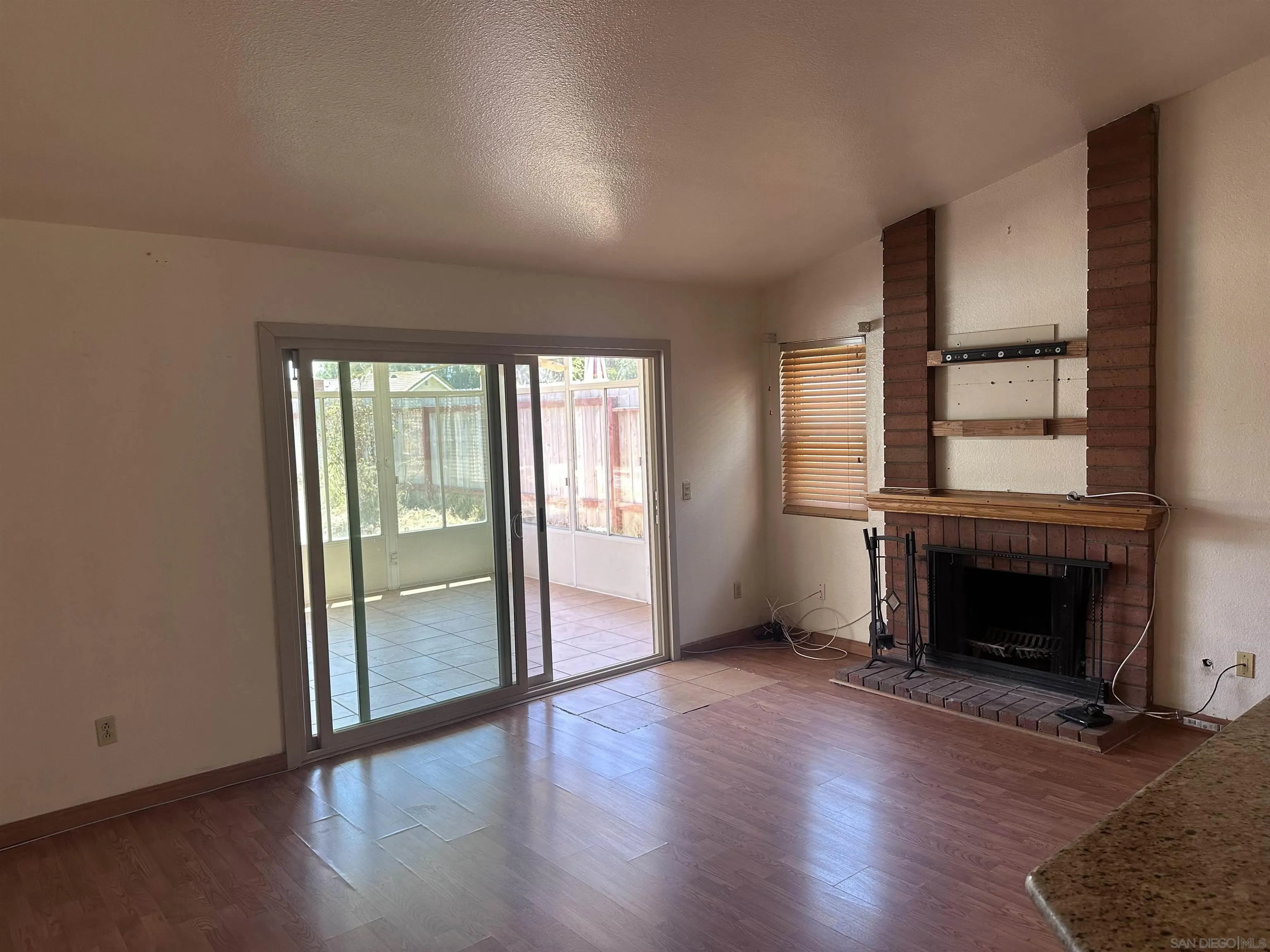 14625 Silverset Street Poway, CA 92064 - Photo 5 of 7 an empty room with wooden floor fireplace and windows