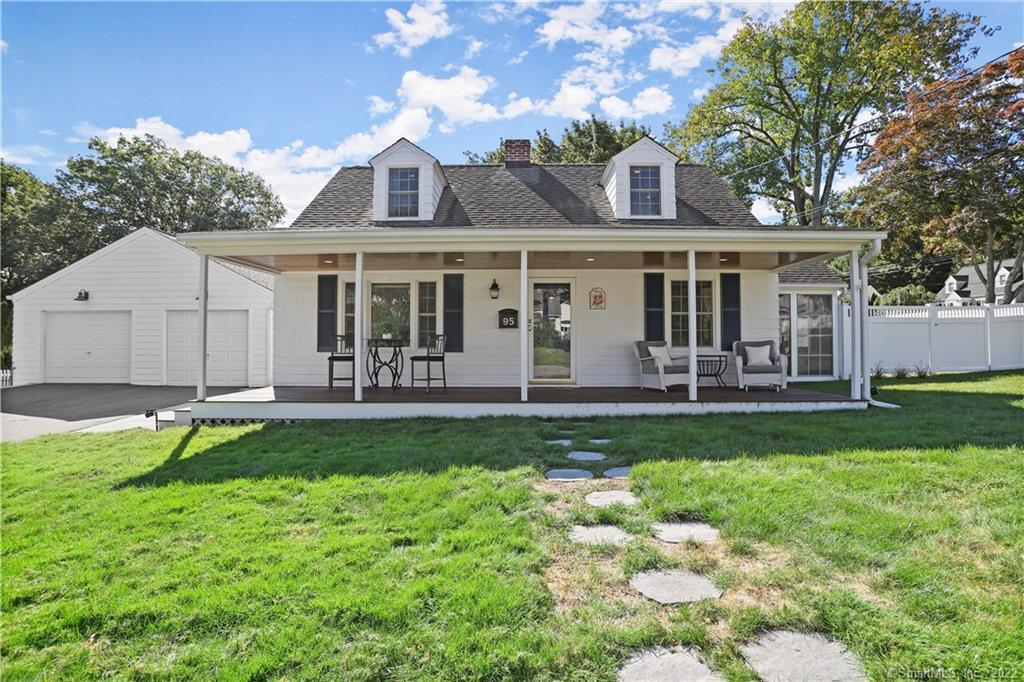 a front view of a house with a yard and trees