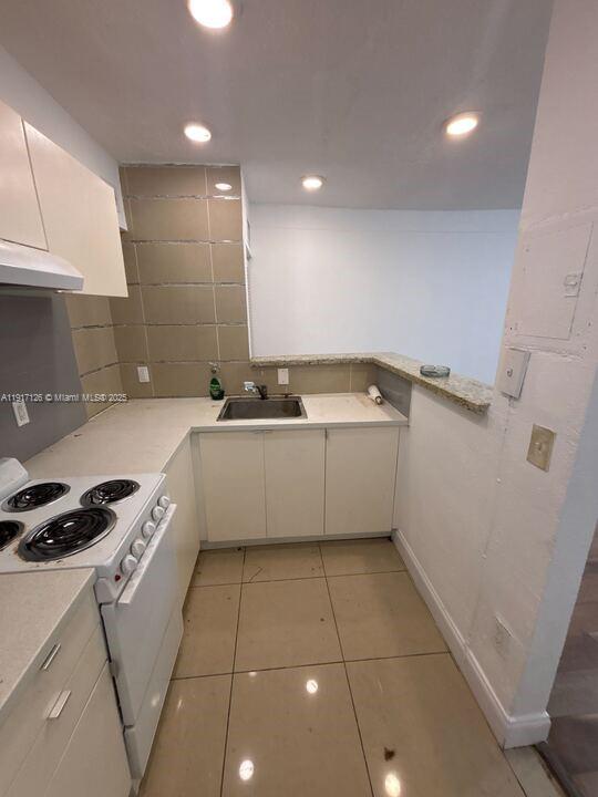 542 Northwest 8th Street, Unit 12 Miami, FL 33136 - Photo 2 of 14 a kitchen with a sink a stove cabinets and a counter top space