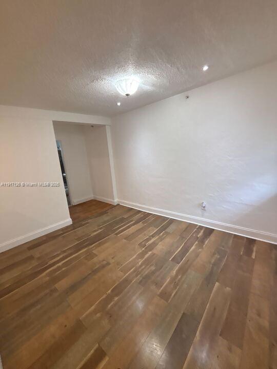 542 Northwest 8th Street, Unit 12 Miami, FL 33136 - Photo 5 of 14 an empty room with wooden floor and windows