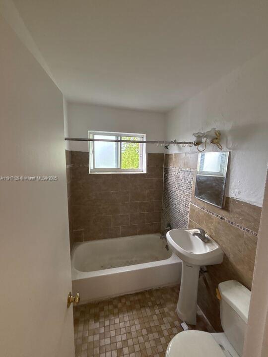 542 Northwest 8th Street, Unit 12 Miami, FL 33136 - Photo 6 of 14 a bathroom with a bath tub a sink and a mirror