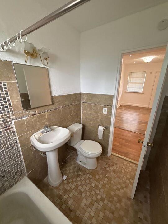 542 Northwest 8th Street, Unit 12 Miami, FL 33136 - Photo 7 of 14 a white toilet sitting next to a bathroom sink