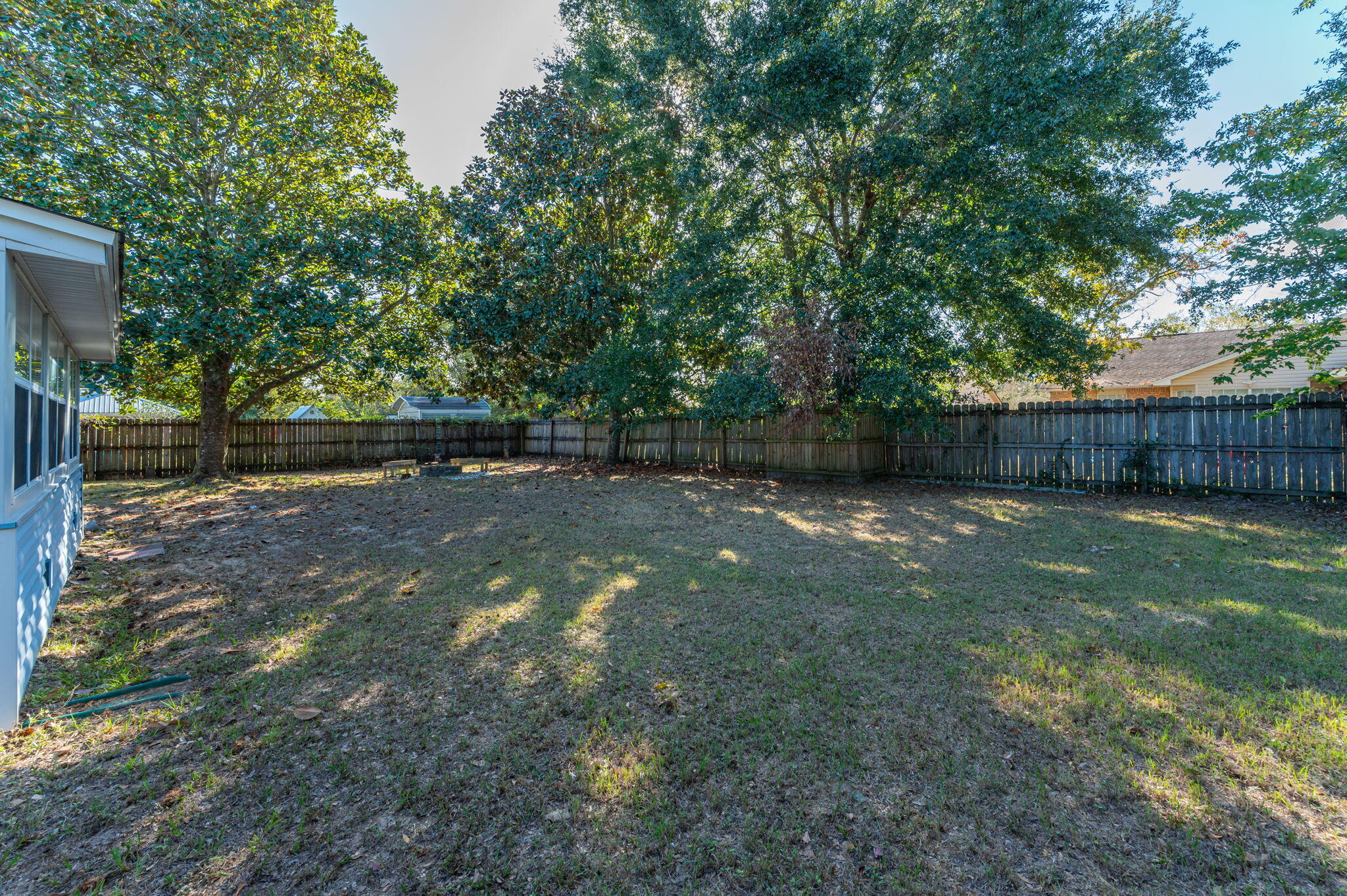 9 Holly Road Crestview, FL 32539 - Photo 31 of 32 a view of a backyard with large trees and wooden fence