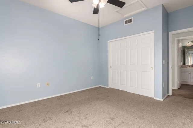 an empty room with a ceiling fan and a window