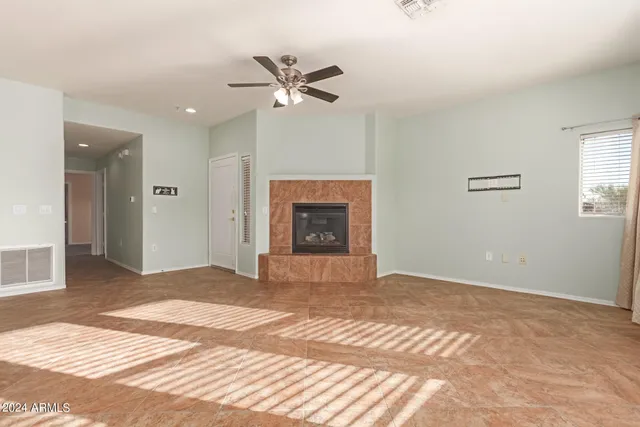 a view of an empty room with a fireplace and a window