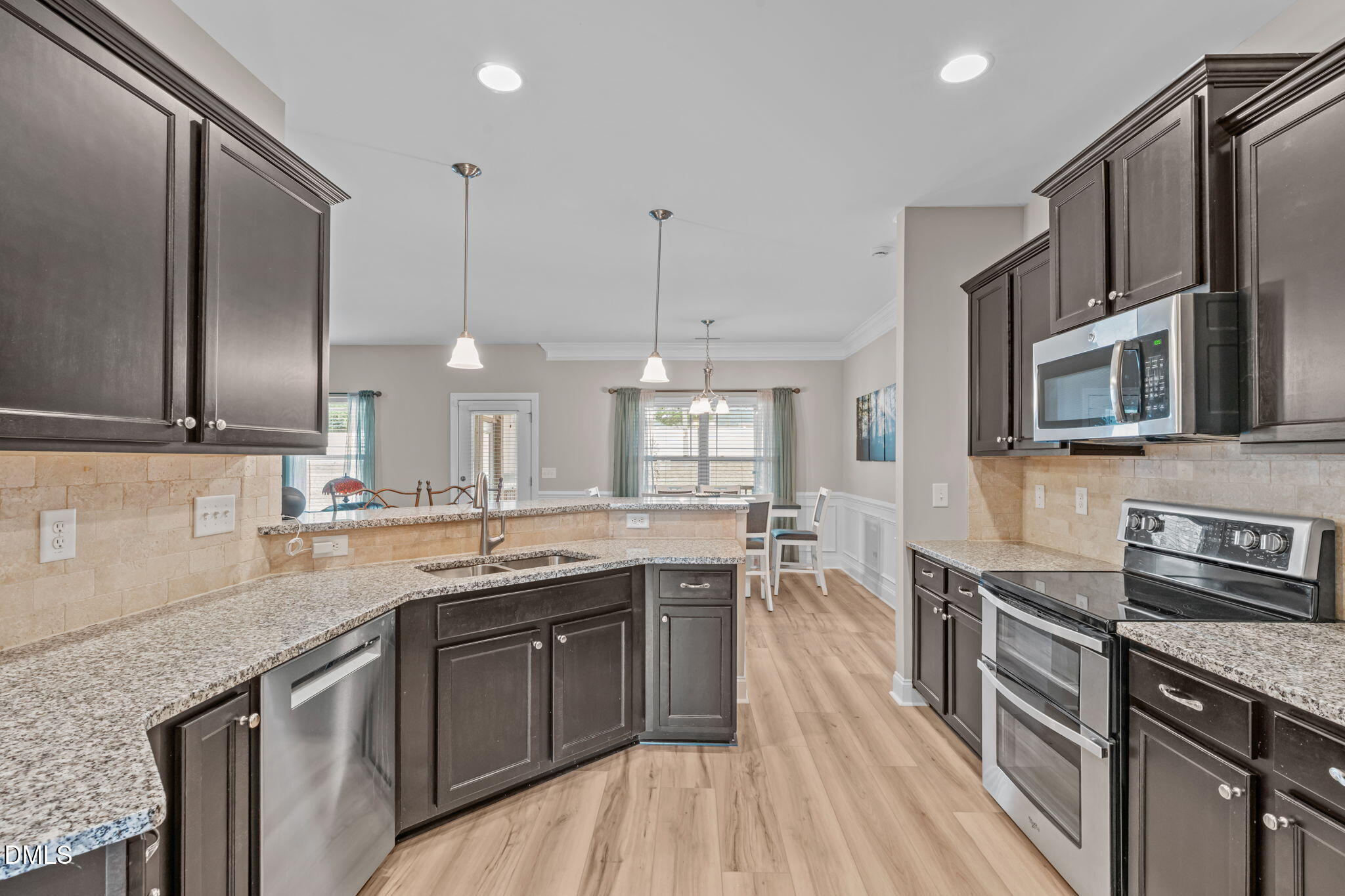 90 Cypress Ridge Way. Willow Spring, NC 27592 - Photo 11 of 52 a kitchen with stainless steel appliances granite countertop a sink a stove and a wooden floors