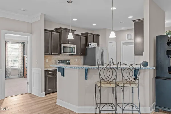 a kitchen with stainless steel appliances kitchen island granite countertop a refrigerator and a stove top oven