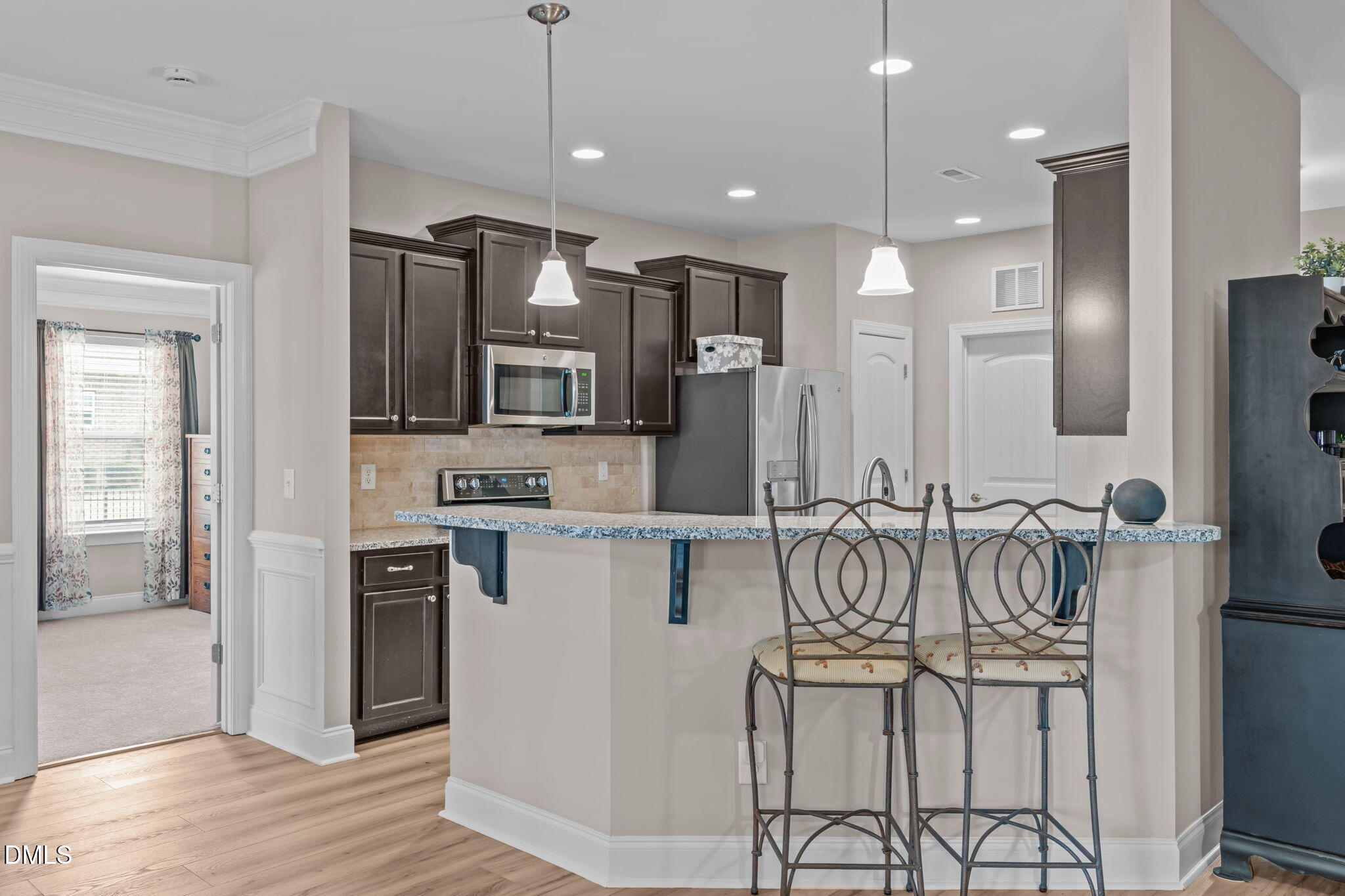 90 Cypress Ridge Way. Willow Spring, NC 27592 - Photo 9 of 52 a kitchen with stainless steel appliances kitchen island granite countertop a refrigerator and a stove top oven