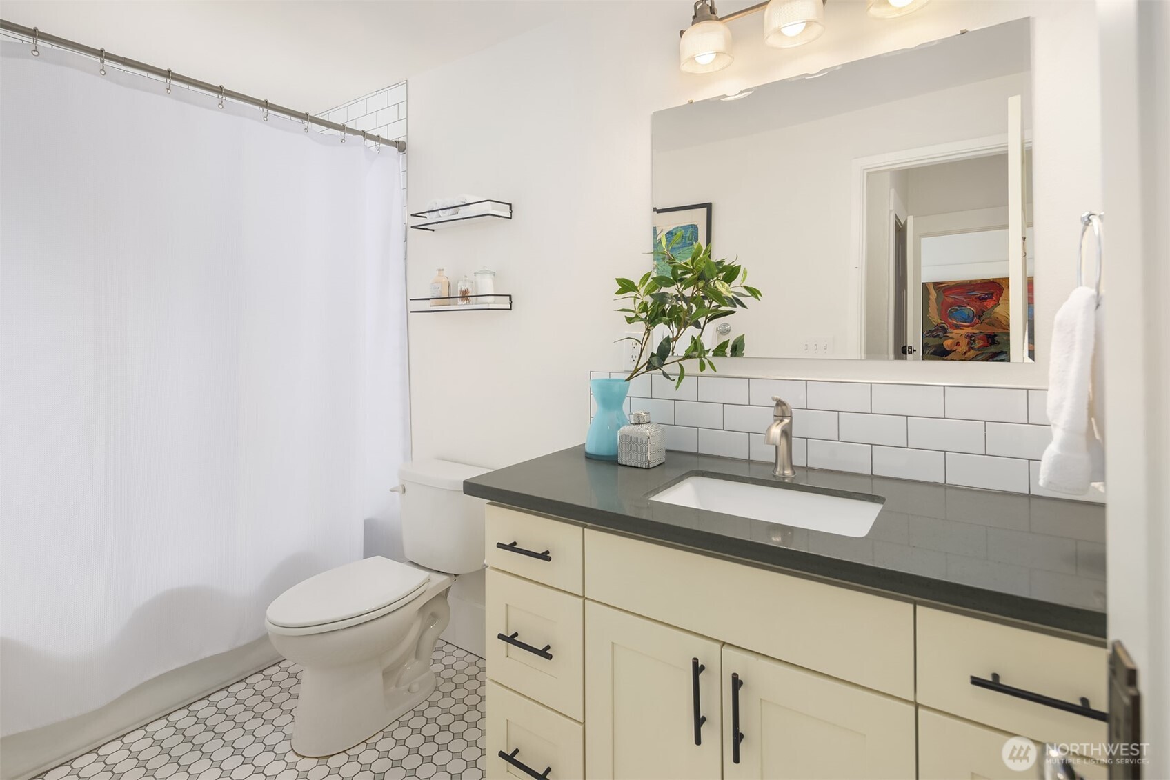 914 West Howe Street Seattle, WA 98119 - Photo 17 of 29 a bathroom with a granite countertop sink a toilet and mirror