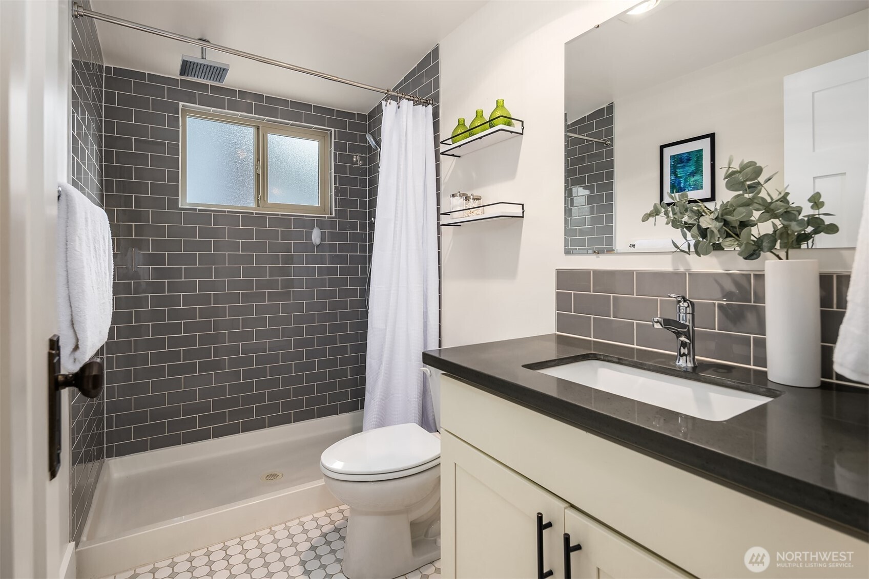 914 West Howe Street Seattle, WA 98119 - Photo 23 of 29 a bathroom with a granite countertop sink toilet a mirror a vanity and shower