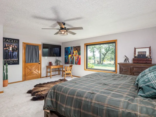 a bedroom with a bed and large windows