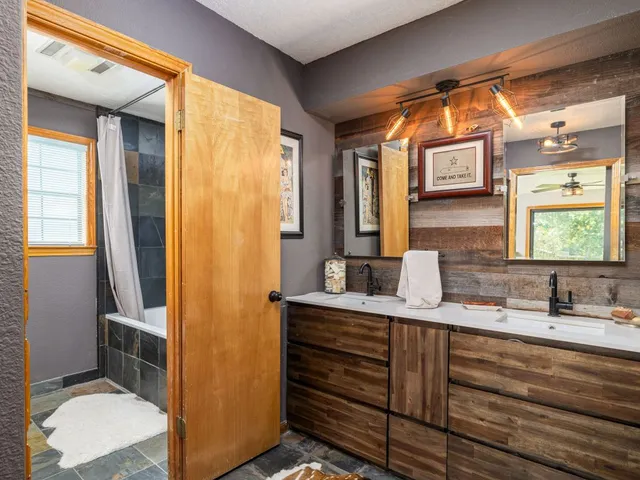 a bathroom with a double vanity sink toilet and mirror