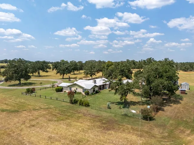 an aerial view of residential house with pool and yard