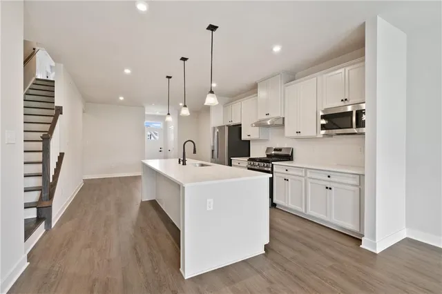 a kitchen with white cabinets and stainless steel appliances
