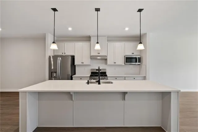 a kitchen with kitchen island a counter top space appliances and cabinets